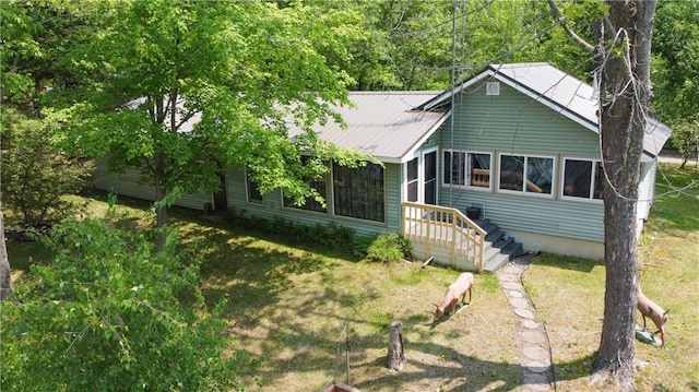 999 Mcgill Point Rd, Weyerhaeuser, WI 54895 - view of front of home with metal roof, a front lawn, and a sunroom