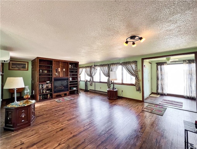 999 Mcgill Point Rd, Weyerhaeuser, WI 54895 - living area with a textured ceiling, a baseboard heating unit, wood finished floors, baseboards, and a wall mounted AC