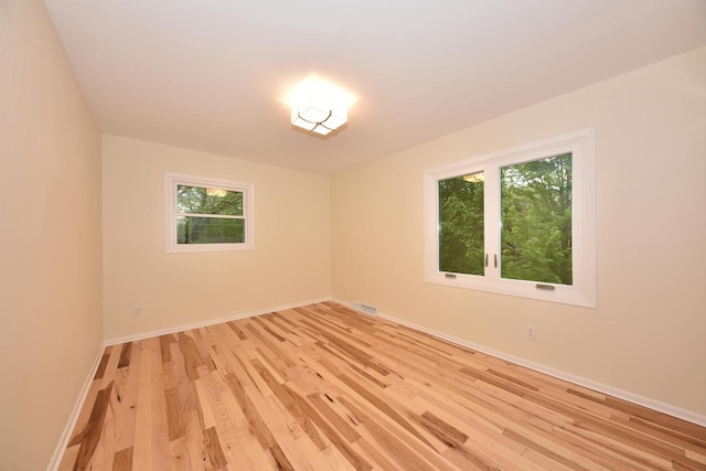 15710 Kata Dr, Elm Grove, WI 53122 - empty room with healthy amount of natural light, light wood finished floors, and baseboards