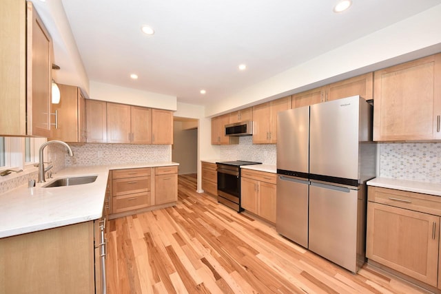 15710 Kata Dr, Elm Grove, WI 53122 - kitchen featuring appliances with stainless steel finishes, a sink, light brown cabinets, light wood-type flooring, and tasteful backsplash