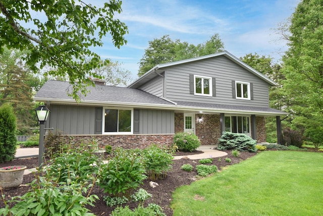 15710 Kata Dr, Elm Grove, WI 53122 - view of front of house featuring a front lawn, board and batten siding, roof with shingles, brick siding, and a chimney