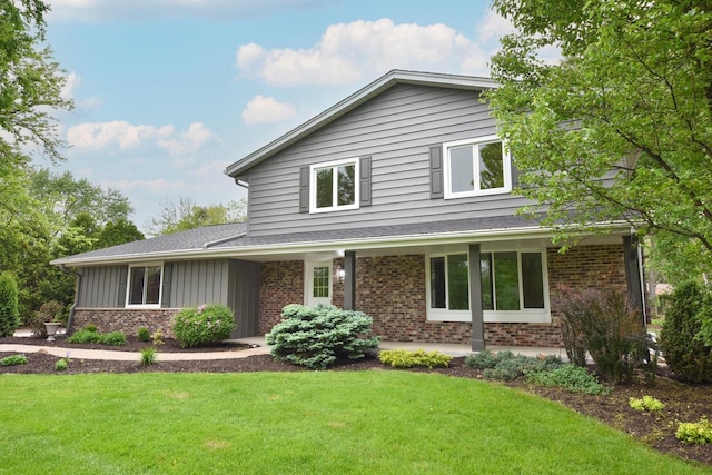 15710 Kata Dr, Elm Grove, WI 53122 - view of front of house with brick siding, a front yard, board and batten siding, and a shingled roof