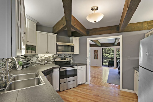 940 Alpine Dr Unit 01, Fontana, WI 53125 - kitchen with stainless steel appliances, a sink, backsplash, light wood finished floors, and beamed ceiling