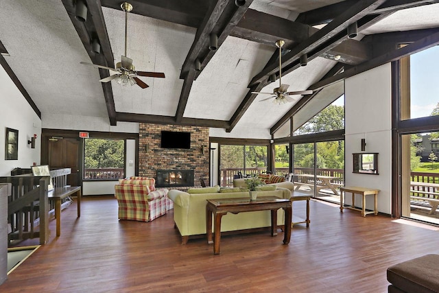 940 Alpine Dr Unit 01, Fontana, WI 53125 - living area featuring a ceiling fan, high vaulted ceiling, wood finished floors, beamed ceiling, and a fireplace