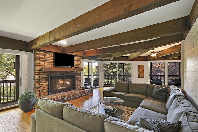 940 Alpine Dr Unit 01, Fontana, WI 53125 - living area featuring beamed ceiling, hardwood / wood-style flooring, a fireplace, plenty of natural light, and ceiling fan