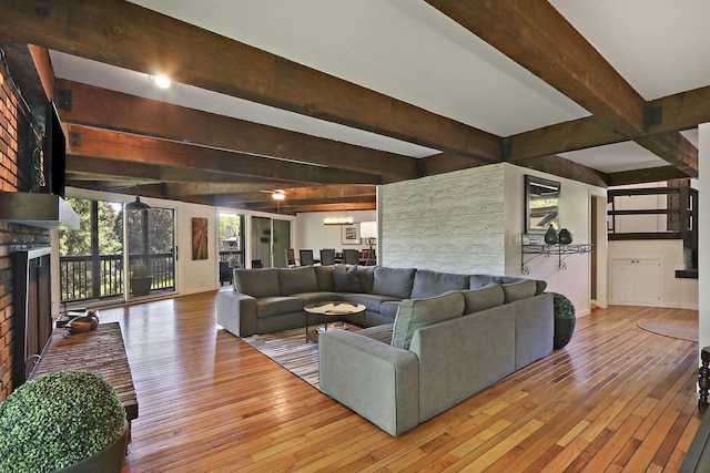 940 Alpine Dr Unit 01, Fontana, WI 53125 - living room featuring beam ceiling, hardwood / wood-style floors, baseboards, and a brick fireplace