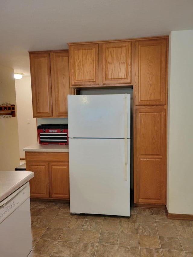 2832 E Somers Ct, Cudahy, WI 53110 - kitchen with white appliances, light countertops, brown cabinets, and stone finish floors