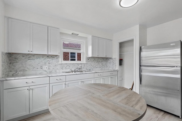 3612 N 57th St, Milwaukee, WI 53216 - kitchen with freestanding refrigerator, a sink, backsplash, light countertops, and white cabinets
