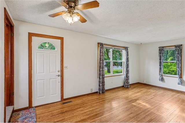 201 5th St, Centuria, WI 54824 - entryway with a textured ceiling, healthy amount of natural light, light wood-type flooring, baseboards, and ceiling fan
