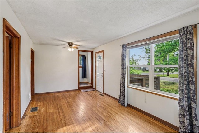 201 5th St, Centuria, WI 54824 - spare room featuring a textured ceiling, baseboards, light wood finished floors, and ceiling fan