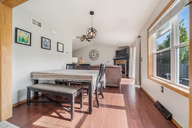 2759 Hamilton St, Oshkosh, WI 54901 - dining area featuring wood finished floors, vaulted ceiling, baseboards, and a glass covered fireplace