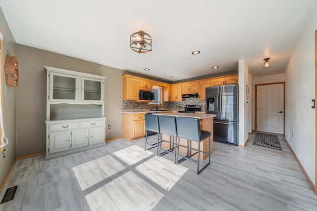 2759 Hamilton St, Oshkosh, WI 54901 - kitchen with black appliances, extractor fan, tasteful backsplash, light wood-style floors, and recessed lighting