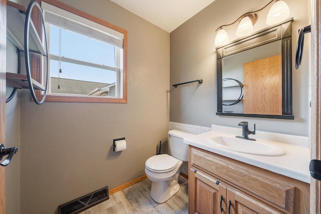 2759 Hamilton St, Oshkosh, WI 54901 - half bath featuring toilet, vanity, wood finished floors, and baseboards