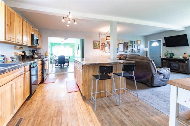 1843 190th St, Centuria, WI 54824 - kitchen with light brown cabinets, stainless steel appliances, a kitchen breakfast bar, light wood-style floors, and open floor plan