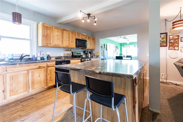 1843 190th St, Centuria, WI 54824 - kitchen with black microwave, stainless steel range with gas stovetop, a sink, light brown cabinetry, and ceiling fan
