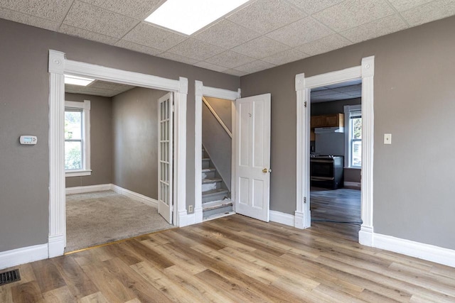 912 N Richmond St, Appleton, WI 54911 - spare room with wood finished floors, stairs, baseboards, and a drop ceiling