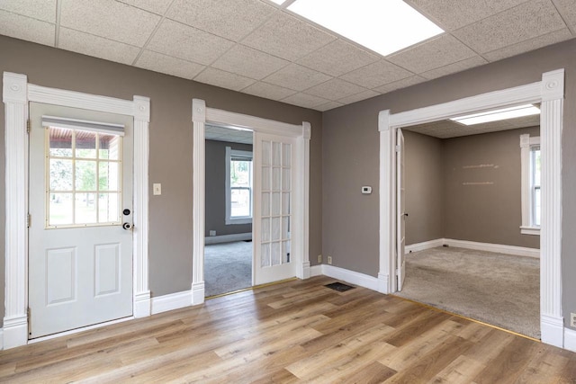 912 N Richmond St, Appleton, WI 54911 - foyer featuring light wood-style flooring, baseboards, a paneled ceiling, and light carpet