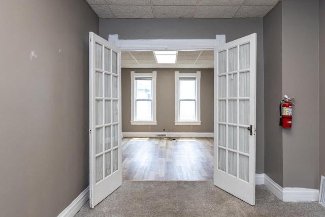 912 N Richmond St, Appleton, WI 54911 - hallway featuring a paneled ceiling, baseboards, french doors, and carpet