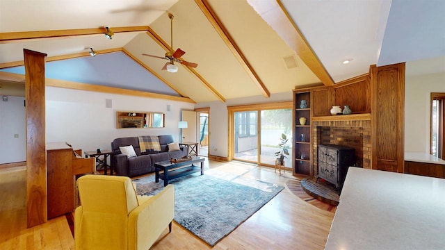 202602 County Road T, Marshfield, WI 54449 - living area featuring light wood finished floors, beam ceiling, a wood stove, ceiling fan, and high vaulted ceiling