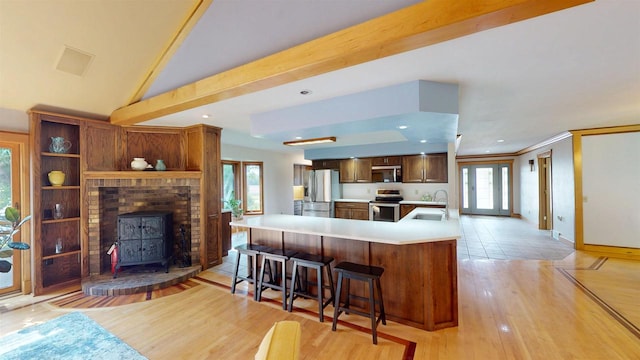 202602 County Road T, Marshfield, WI 54449 - kitchen featuring a sink, appliances with stainless steel finishes, light countertops, a kitchen bar, and a wood stove