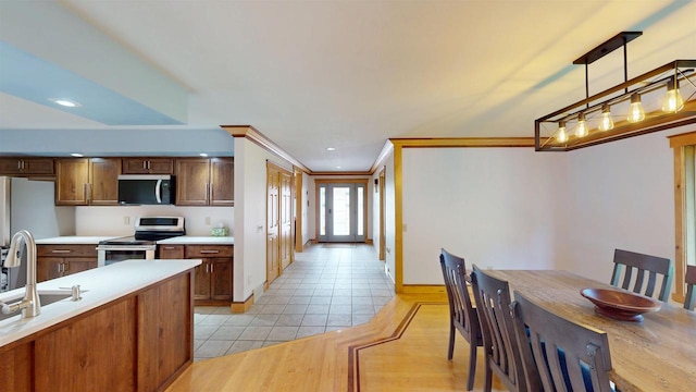 202602 County Road T, Marshfield, WI 54449 - kitchen featuring stainless steel appliances, light countertops, hanging light fixtures, a sink, and ornamental molding