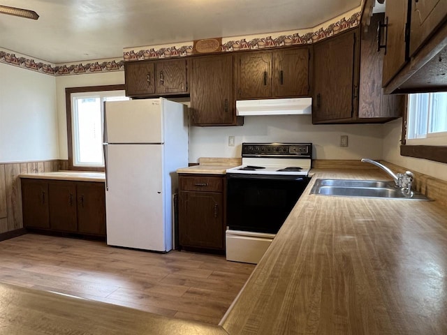 856 8th St, Beloit, WI 53511 - kitchen with range with electric stovetop, freestanding refrigerator, under cabinet range hood, a sink, and dark brown cabinets