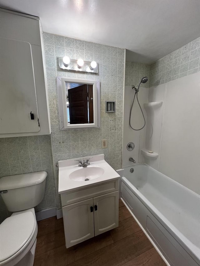 856 8th St, Beloit, WI 53511 - full bathroom with toilet, vanity, wood finished floors, washtub / shower combination, and tile walls