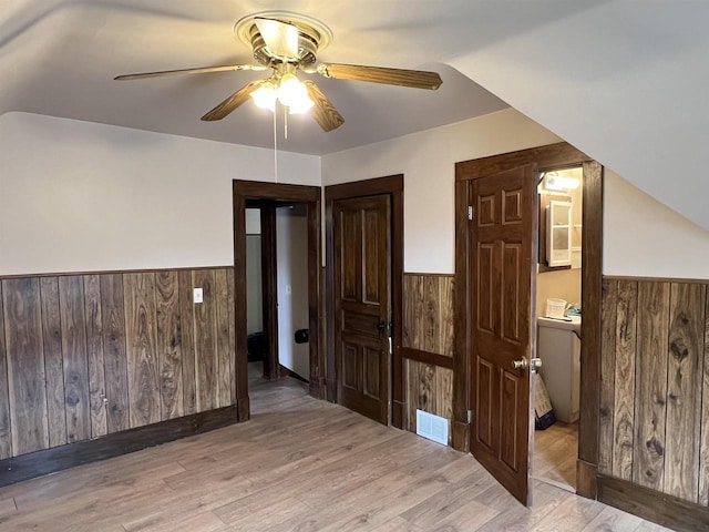 856 8th St, Beloit, WI 53511 - spare room featuring ceiling fan, a wainscoted wall, wood walls, and wood finished floors