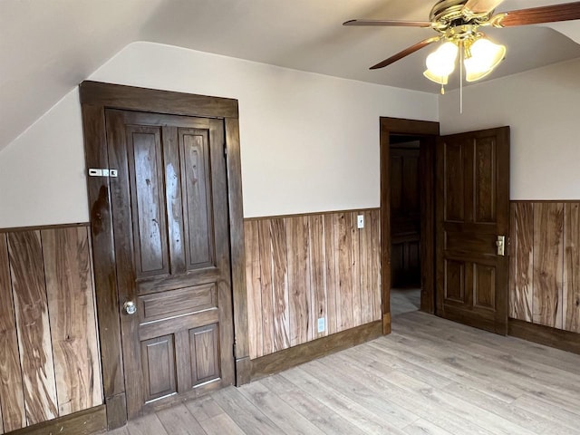 856 8th St, Beloit, WI 53511 - interior space with wainscoting, wood walls, light wood-type flooring, vaulted ceiling, and a ceiling fan