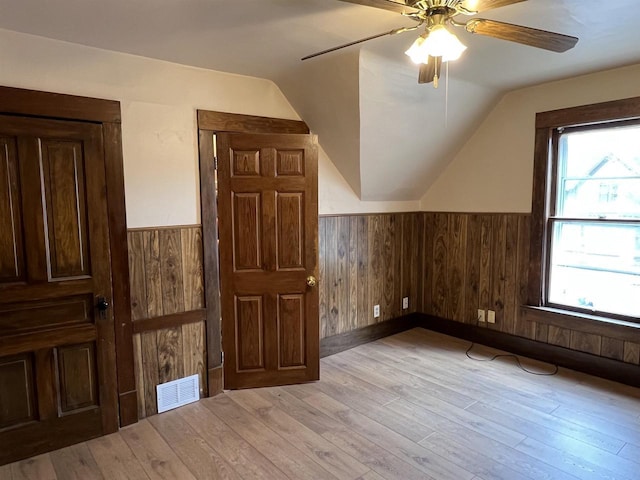 856 8th St, Beloit, WI 53511 - additional living space featuring wainscoting, vaulted ceiling, light wood finished floors, ceiling fan, and wooden walls