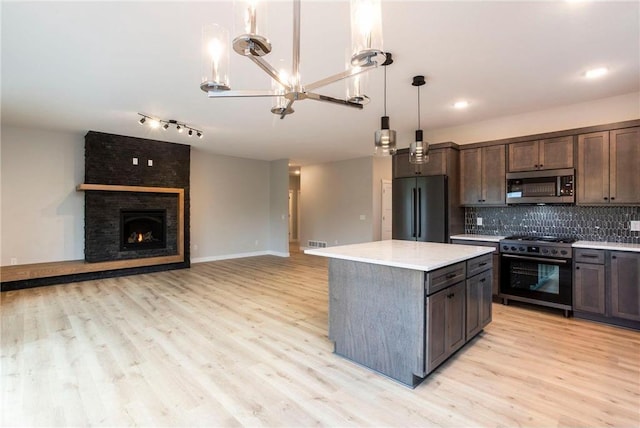 415 Moelter Ln, Hudson, WI 54016 - kitchen with stainless steel appliances, a chandelier, light countertops, and light wood-style flooring