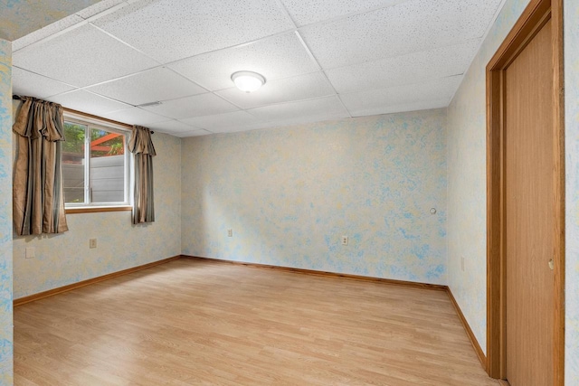 9432 James Ave, Sparta, WI 54656 - empty room featuring light wood-style floors, a paneled ceiling, baseboards, and wallpapered walls