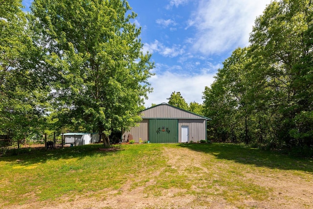 9432 James Ave, Sparta, WI 54656 - view of green lawn featuring an outbuilding, an outdoor structure, a garage, and driveway