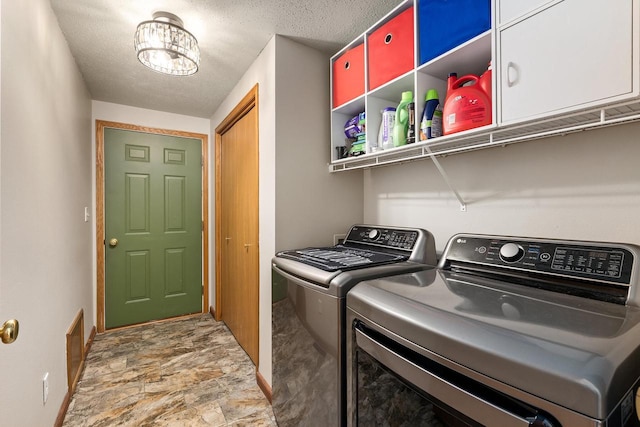 9432 James Ave, Sparta, WI 54656 - laundry area featuring cabinet space, separate washer and dryer, stone finish floors, baseboards, and a textured ceiling