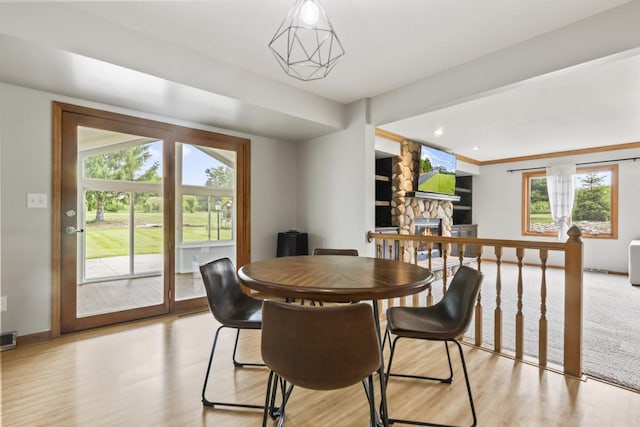 S38W32310 Green Briar Rd, Waukesha, WI 53189 - dining area featuring a stone fireplace, light wood-style flooring, and baseboards