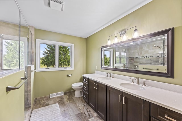 S38W32310 Green Briar Rd, Waukesha, WI 53189 - full bathroom featuring double vanity, a tile shower, toilet, baseboards, and marble finish flooring