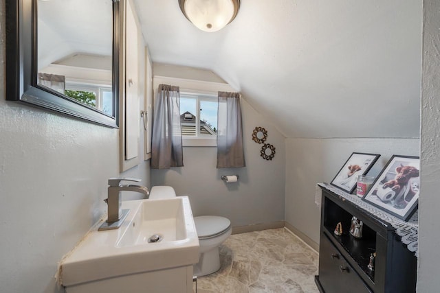 823 De Pere St, Menasha, WI 54952 - bathroom with vaulted ceiling, toilet, vanity, and baseboards