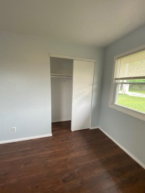 4265 S Nicholson Ave, Saint Francis, WI 53235 - unfurnished bedroom with baseboards, a closet, and dark wood-style flooring