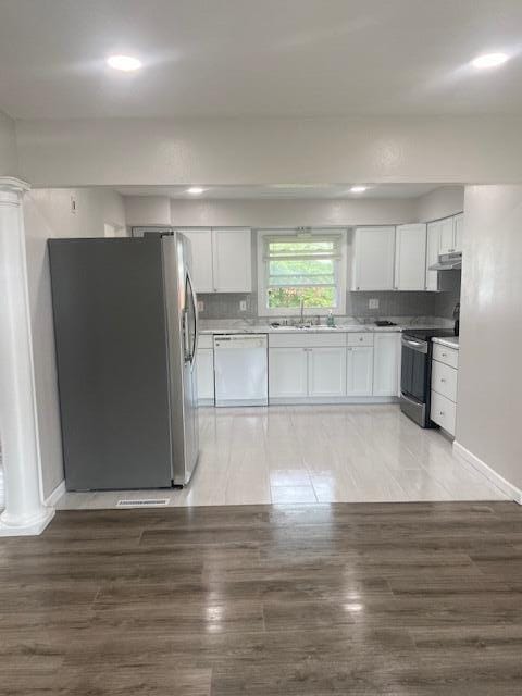 4265 S Nicholson Ave, Saint Francis, WI 53235 - kitchen with appliances with stainless steel finishes, white cabinetry, range hood, light countertops, and a sink
