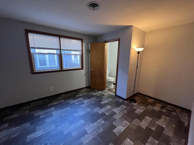 909 College Ave, Racine, WI 53403 - unfurnished bedroom with baseboards and connected bathroom