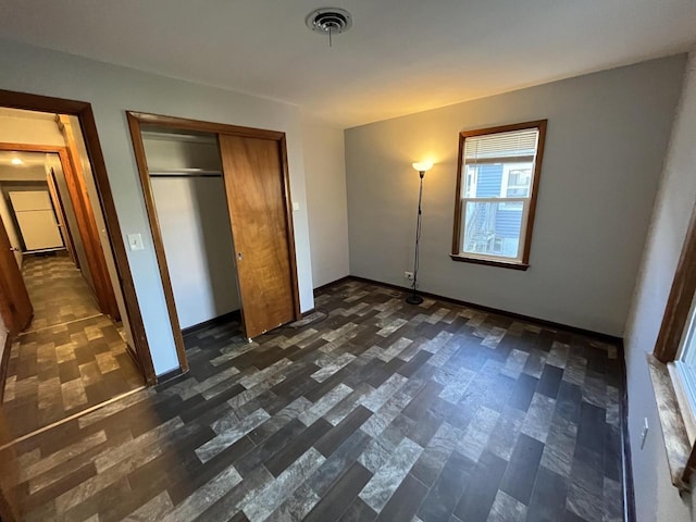 909 College Ave, Racine, WI 53403 - unfurnished bedroom featuring dark wood-type flooring and a closet