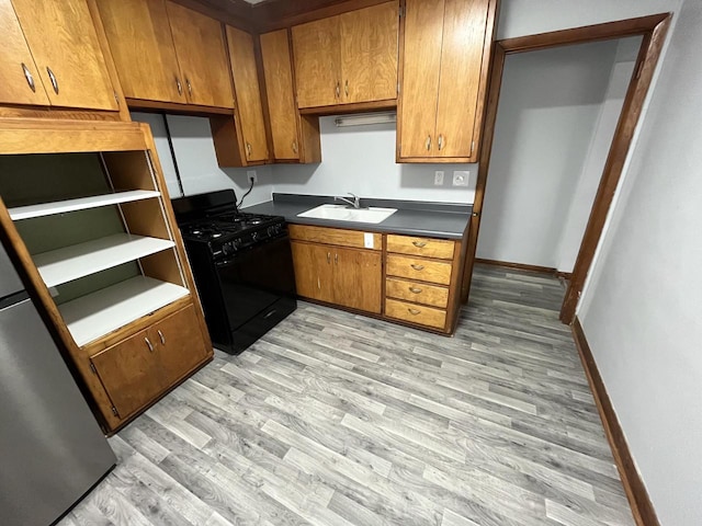 909 College Ave, Racine, WI 53403 - kitchen featuring black range with gas stovetop, light wood-style floors, and brown cabinetry