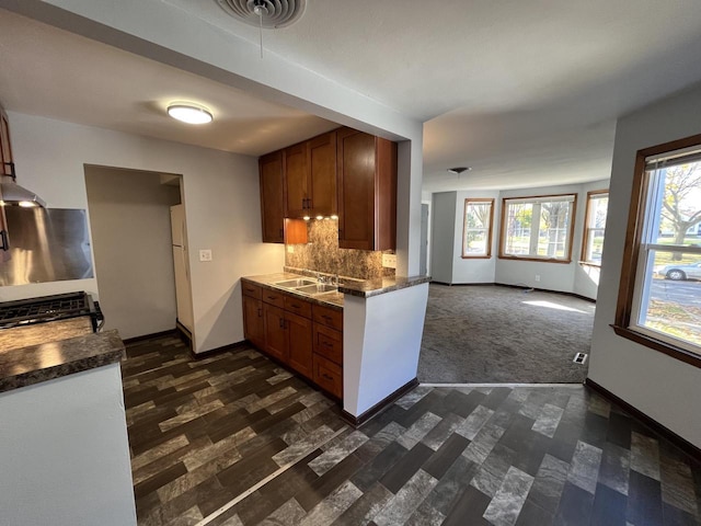 909 College Ave, Racine, WI 53403 - kitchen with stove, dark countertops, tasteful backsplash, exhaust hood, and open floor plan