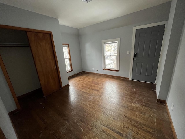 909 College Ave, Racine, WI 53403 - unfurnished bedroom with dark wood-style floors and a closet
