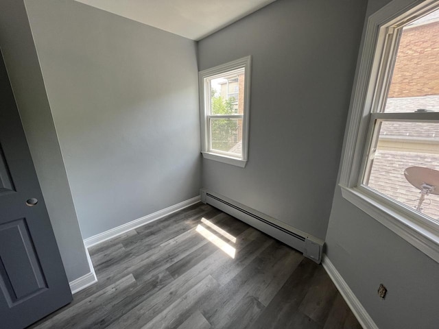 909 College Ave, Racine, WI 53403 - empty room featuring a baseboard heating unit and wood finished floors