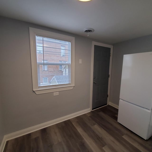 909 College Ave, Racine, WI 53403 - unfurnished dining area with baseboards and dark wood-style floors