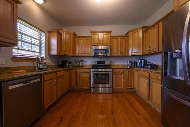 5278 W Highlands Ct, Franklin, WI 53132 - kitchen featuring appliances with stainless steel finishes, a sink, dark wood finished floors, dark stone countertops, and brown cabinets