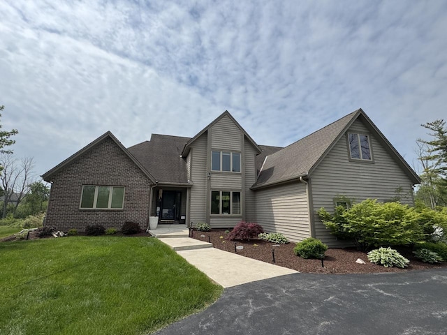 1441 W County Line Rd, River Hills, WI 53217 - traditional-style house with a front yard, brick siding, and a shingled roof