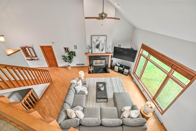 1441 W County Line Rd, River Hills, WI 53217 - living room featuring high vaulted ceiling, a ceiling fan, wood finished floors, and a tile fireplace