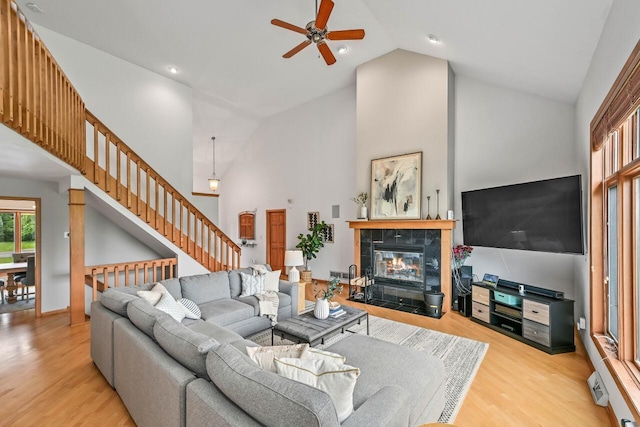 1441 W County Line Rd, River Hills, WI 53217 - living room featuring high vaulted ceiling, wood finished floors, a ceiling fan, stairway, and a fireplace